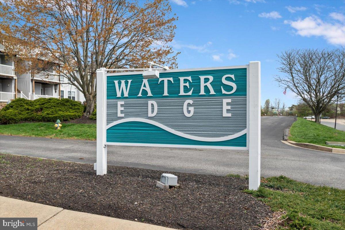 2702 Waters Edge Drive, Unit 2 Newark, DE 19702 - Photo 2 of 25 a sign that is sitting in front of a brick house