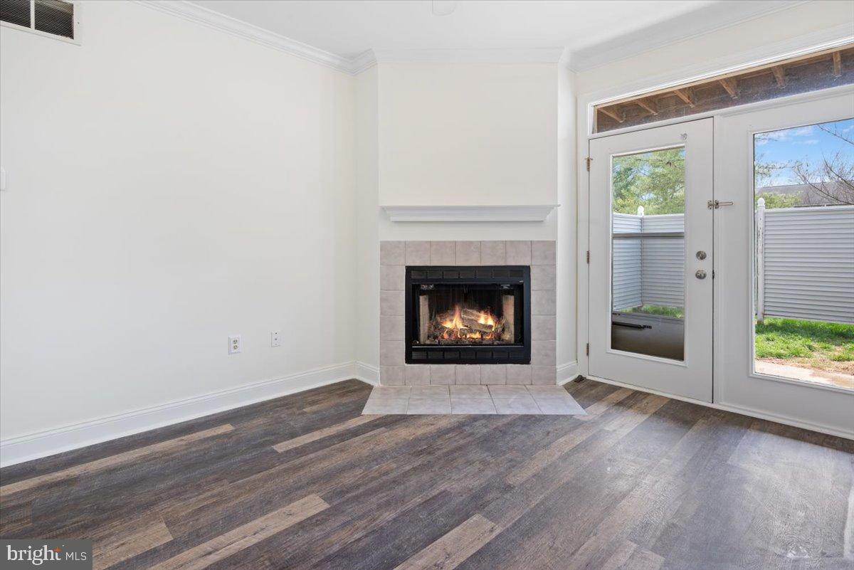 2702 Waters Edge Drive, Unit 2 Newark, DE 19702 - Photo 6 of 25 a view of an empty room with wooden floor fireplace and a window