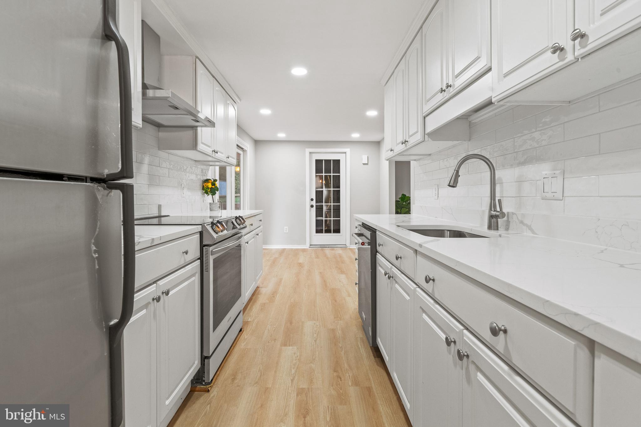 6122 Mantle Road Burke, VA 22015 - Photo 5 of 51 a kitchen with white cabinets and appliances