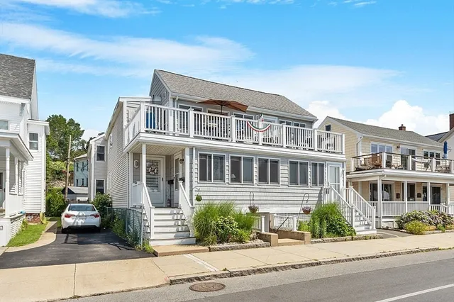 a front view of a house with a garden and balcony