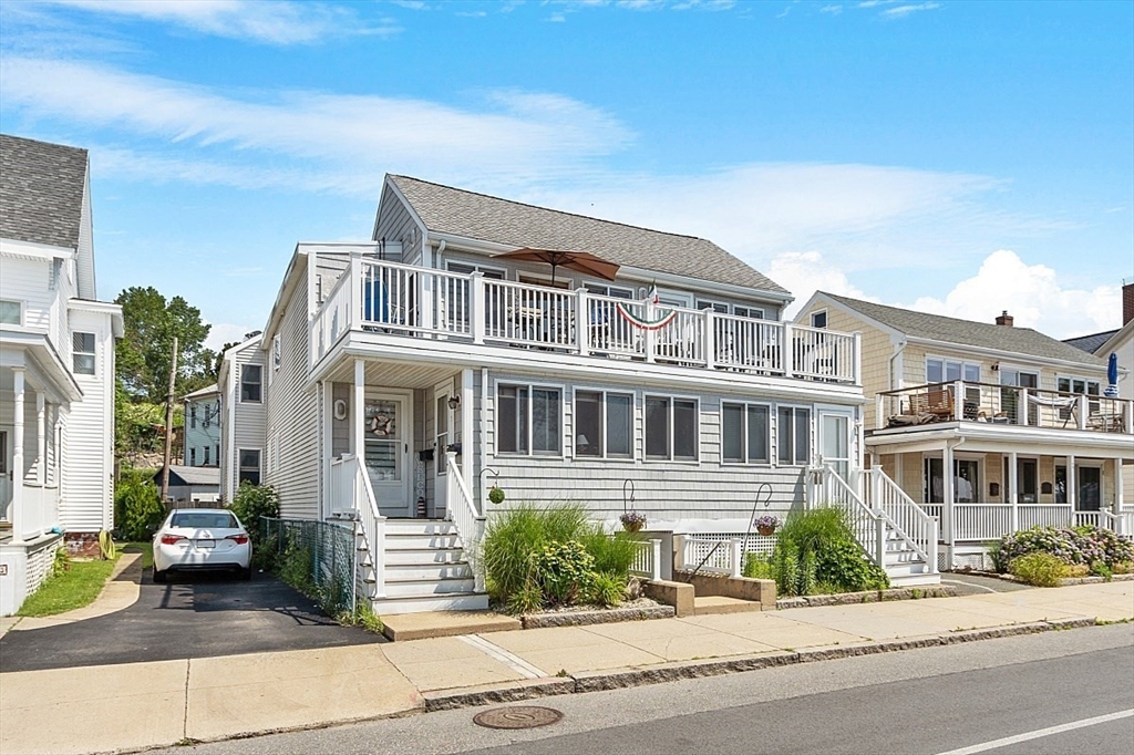 a front view of a house with a garden and balcony