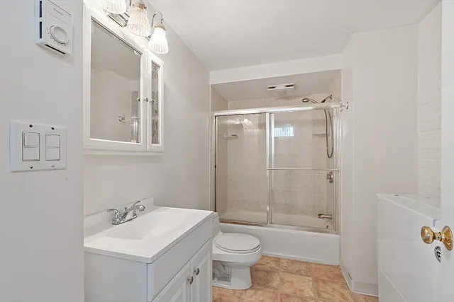 a bathroom with a toilet a sink a mirror a bathtub and shower