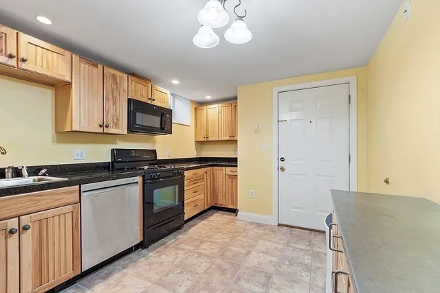 a kitchen with stainless steel appliances granite countertop a refrigerator a stove top oven a sink and dishwasher