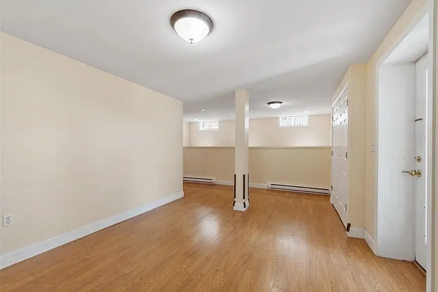 an empty room with wooden floor and a window