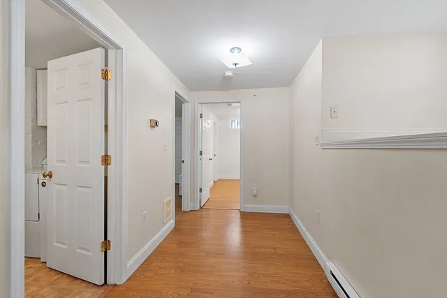 a view of a hallway with wooden floor and closet