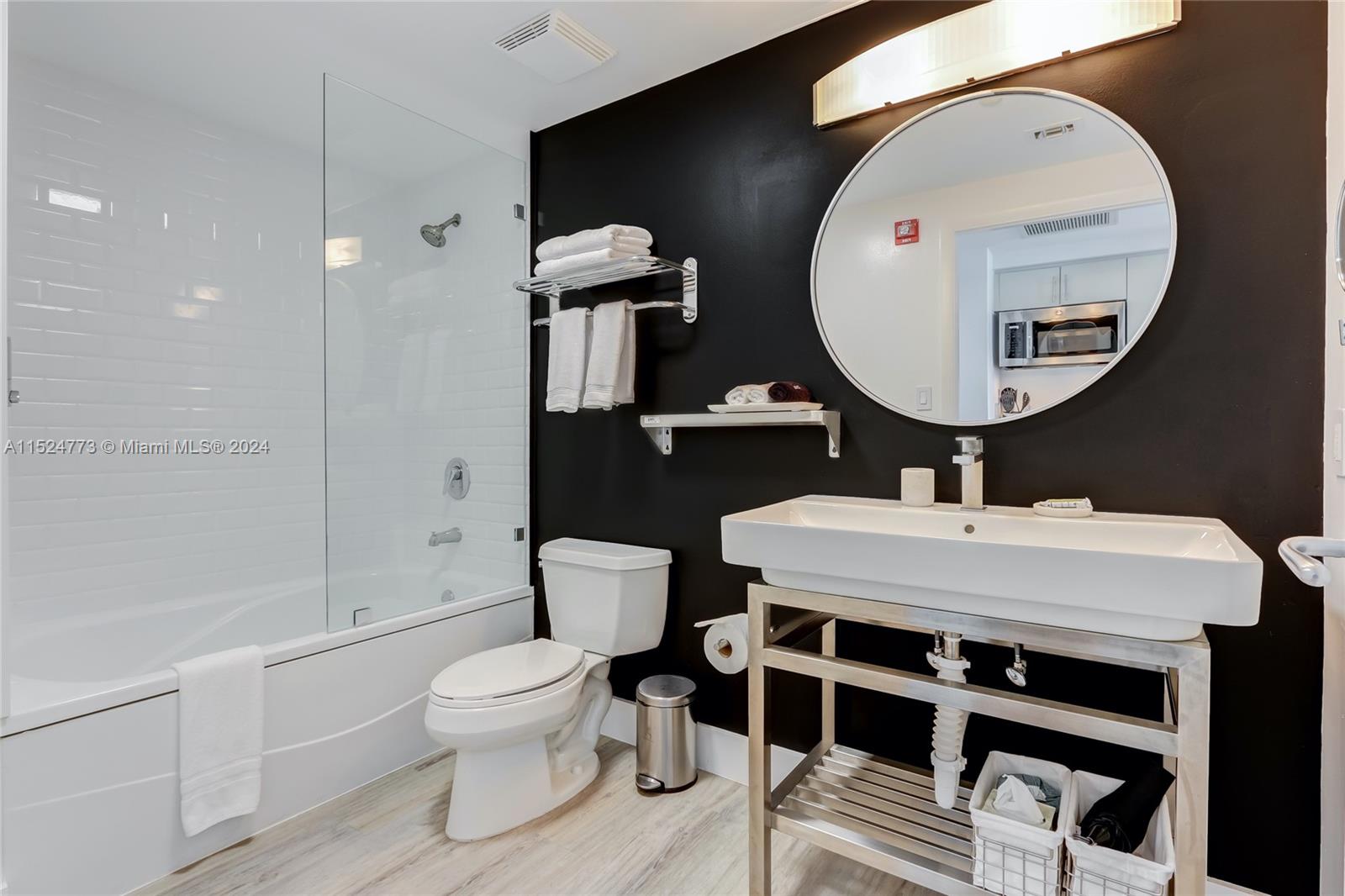 2889 McFarlane Road, Unit 1410 Coconut Grove, FL 33133 - Photo 6 of 8 a bathroom with a toilet a sink and a mirror