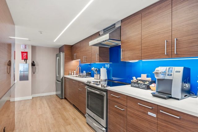 a kitchen with stainless steel appliances granite countertop a sink and a stove
