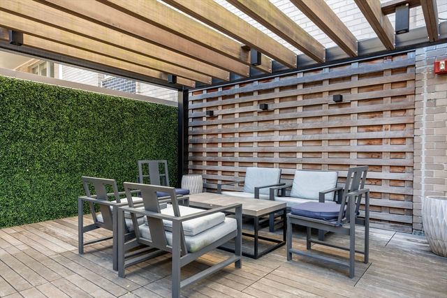 a patio with table and chairs and potted plants