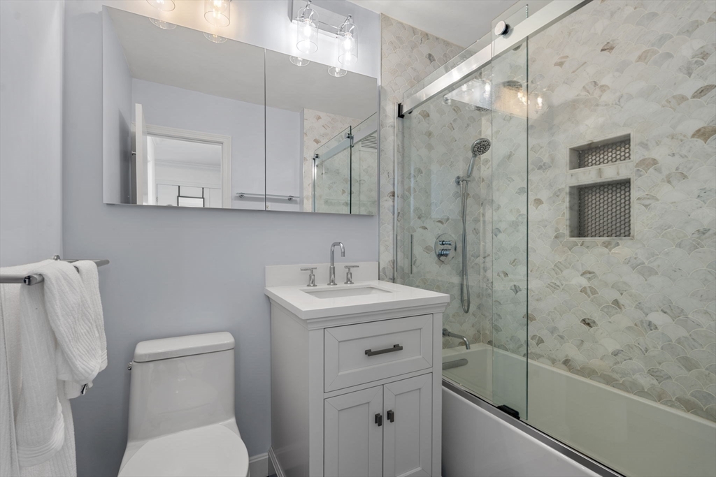 151 Tremont Street, Unit 10S Boston, MA 02111 - Photo 4 of 27 a bathroom with a sink a toilet and shower