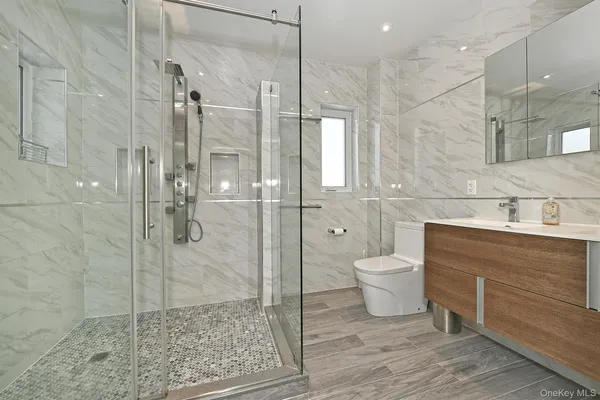 a bathroom with a granite countertop sink a toilet and shower