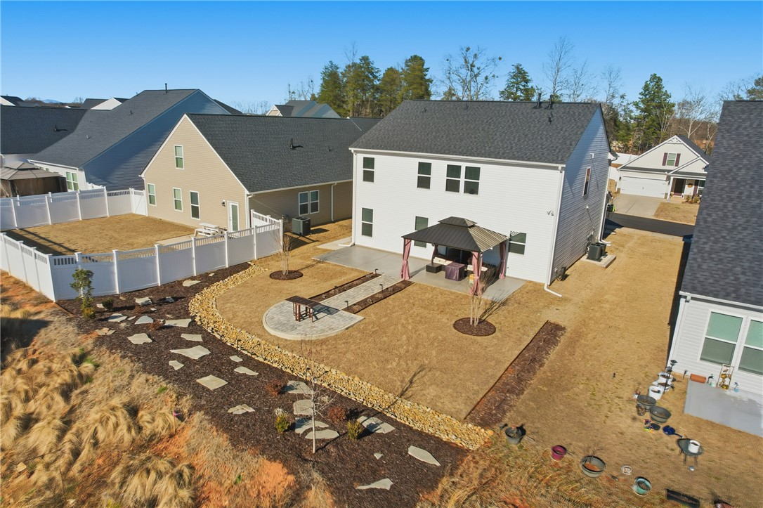 Professionally landscaped backyard made for entertaining and relaxing — featuring an extended patio, stylish gazebo, and paver walkway connecting the backyard to the front of the home. With added sidewalk access and an extra parking pad, this outdoor space is perfect for gathering with friends, enjoying quiet evenings, or simply unwinding at home.