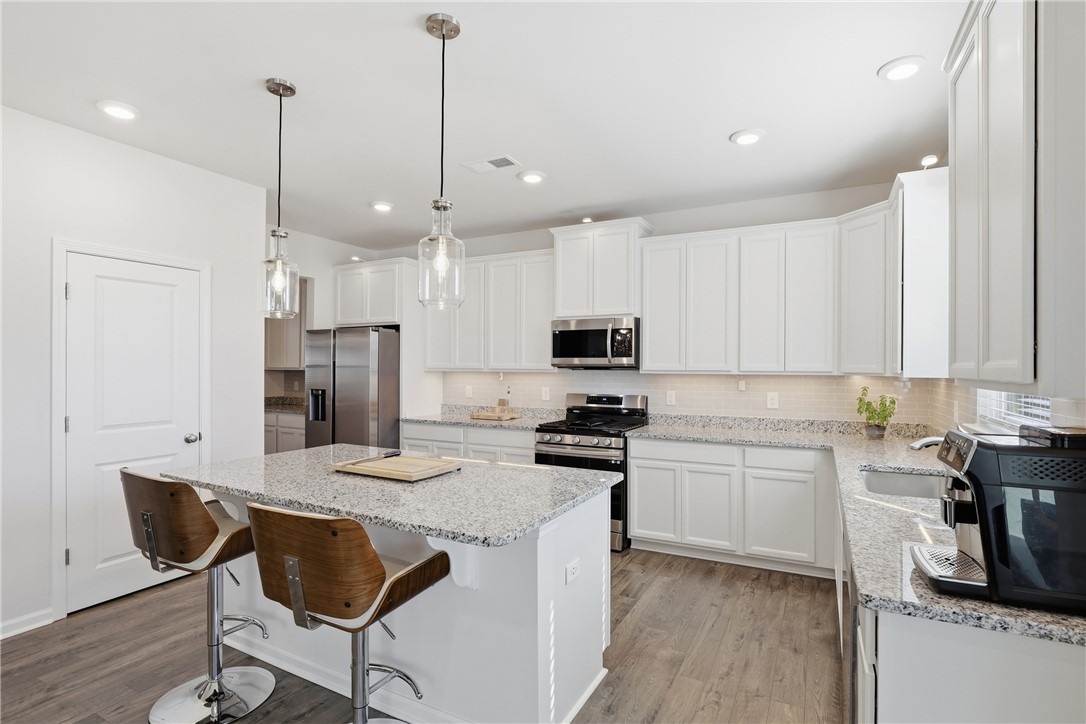 804 Spring Orchard Drive Lyman, SC 29365 - Photo 14 of 47 This bright kitchen features sleek white cabinetry and a convenient island with seating.