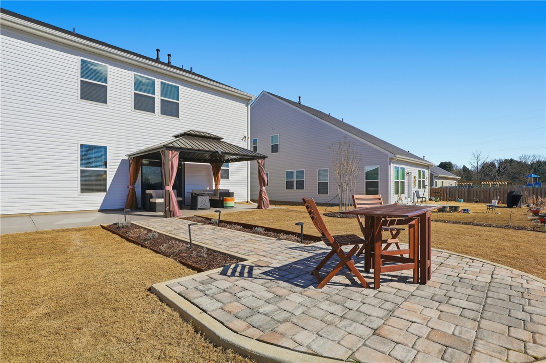 804 Spring Orchard Drive Lyman, SC 29365 - Photo 4 of 47 Imagine cozy nights around the firepit.
This spacious backyard retreat features a beautiful paver patio and private gazebo on an extended patio perfect for relaxing evenings, entertaining friends, and enjoying outdoor living.