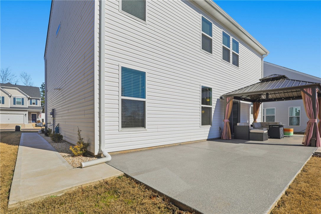 804 Spring Orchard Drive Lyman, SC 29365 - Photo 8 of 47 Enjoy outdoor living on this expansive concrete patio with sidewalk leading from front to back of the house, perfect for relaxation and entertaining.