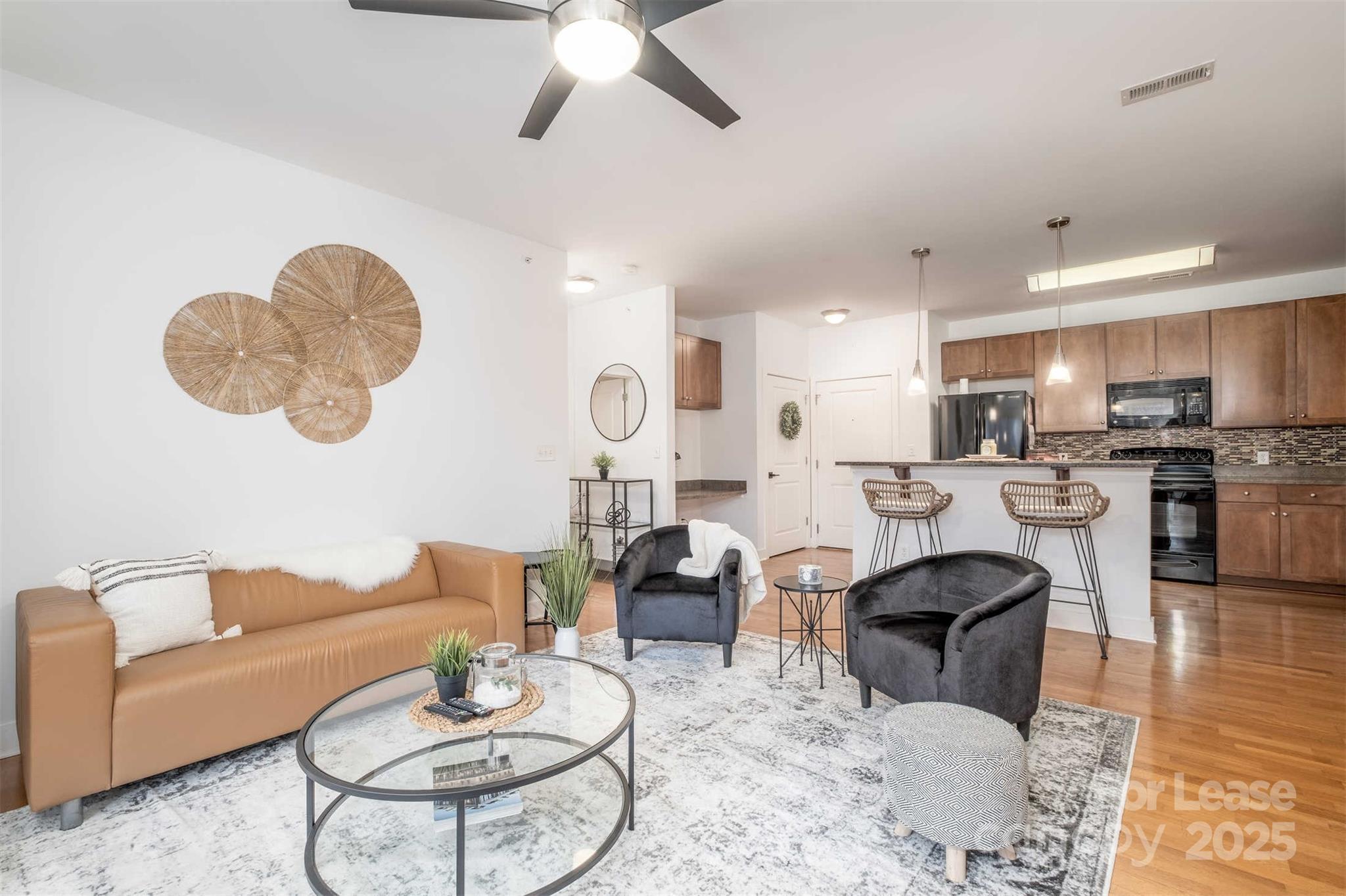 630 Calvert Street, Unit 409 Charlotte, NC 28208 - Photo 2 of 8 a living room with furniture kitchen view and a chandelier