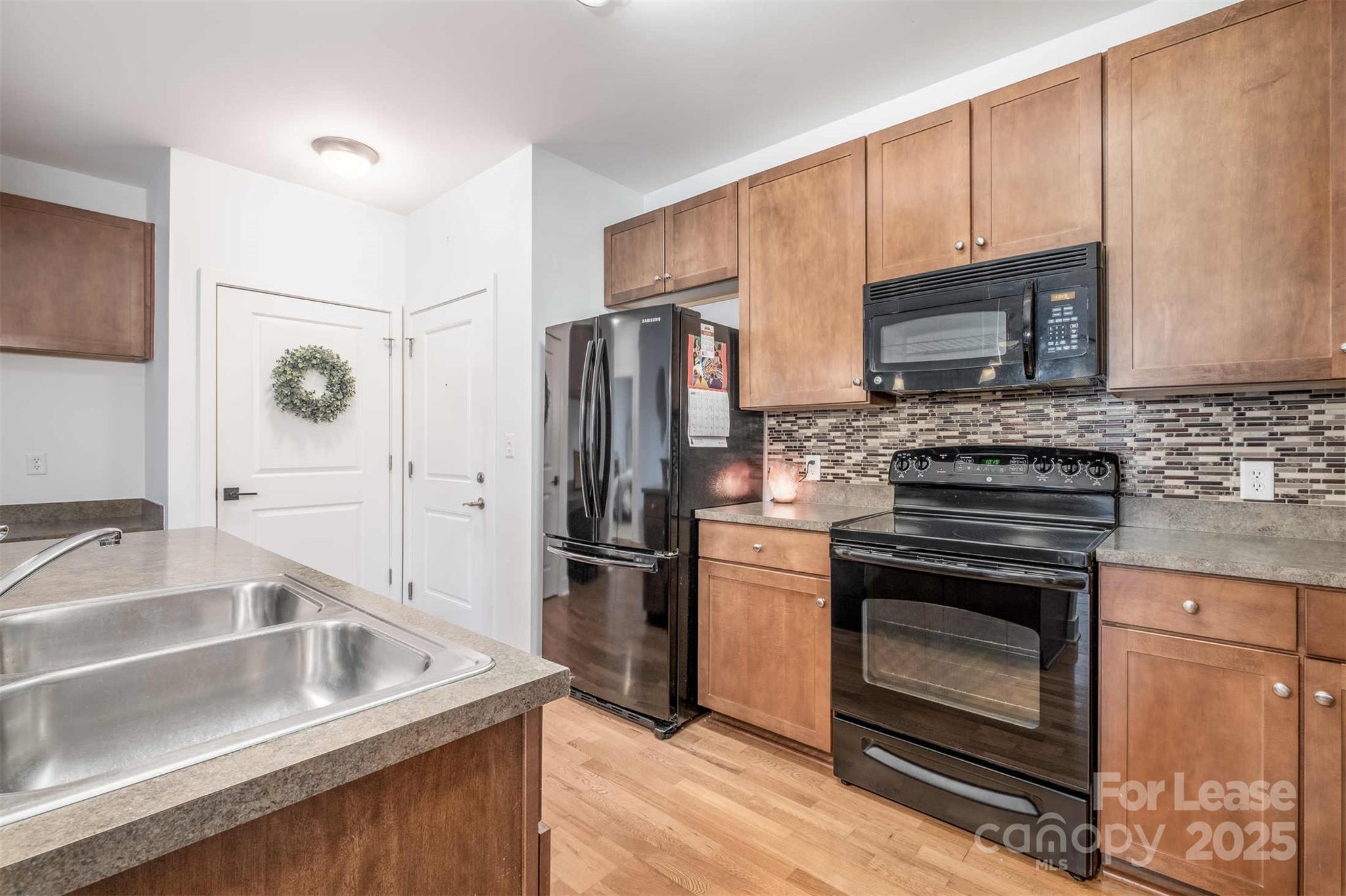 630 Calvert Street, Unit 409 Charlotte, NC 28208 - Photo 4 of 8 a kitchen with stainless steel appliances granite countertop a sink stove and refrigerator