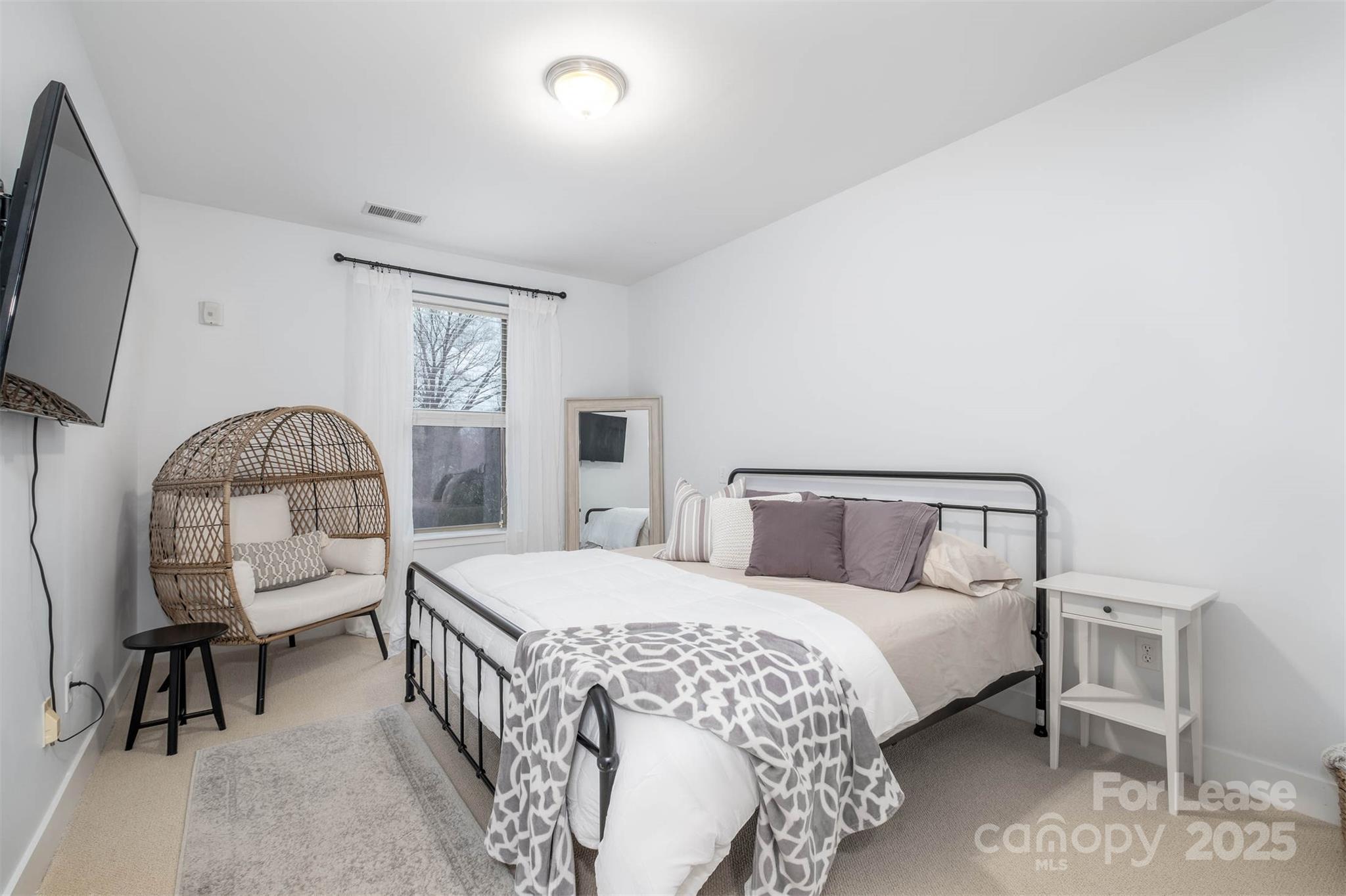 630 Calvert Street, Unit 409 Charlotte, NC 28208 - Photo 5 of 8 a bedroom with a bed window and a chair