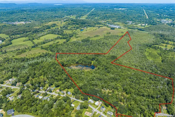 an aerial view of residential houses with outdoor space and trees