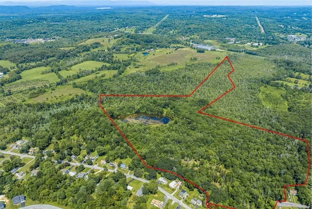 an aerial view of residential houses with outdoor space and trees