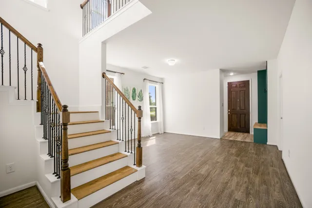 a view of a hallway with wooden floor and entryway