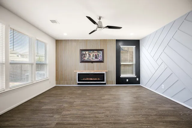 a view of a livingroom with wooden floor and a ceiling fan