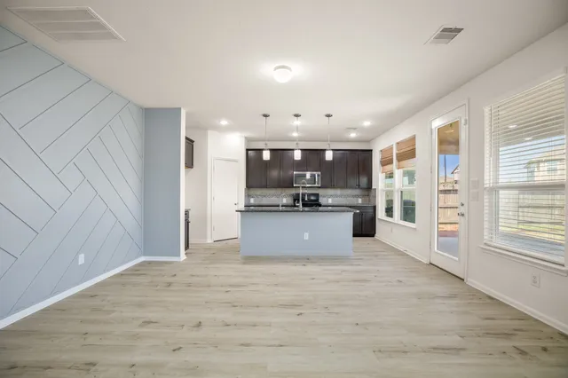 a large kitchen with kitchen island a sink stainless steel appliances and cabinets