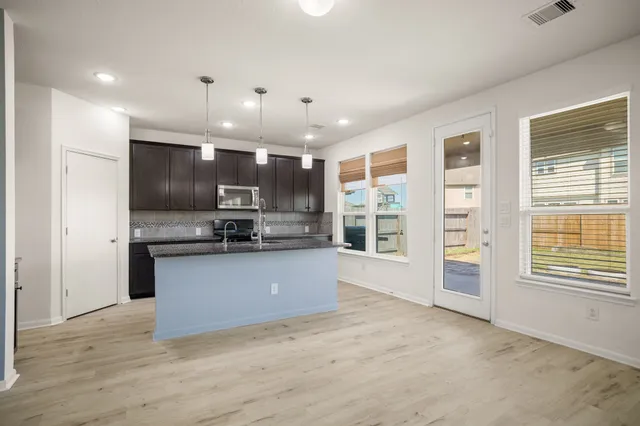 a view of kitchen with kitchen island stainless steel appliances microwave and refrigerator