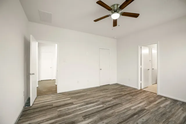 a view of a livingroom with a ceiling fan and wooden floor