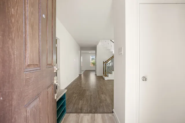 a view of a hallway with wooden floor and staircase