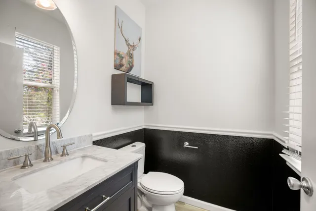 a bathroom with a granite countertop sink toilet and mirror