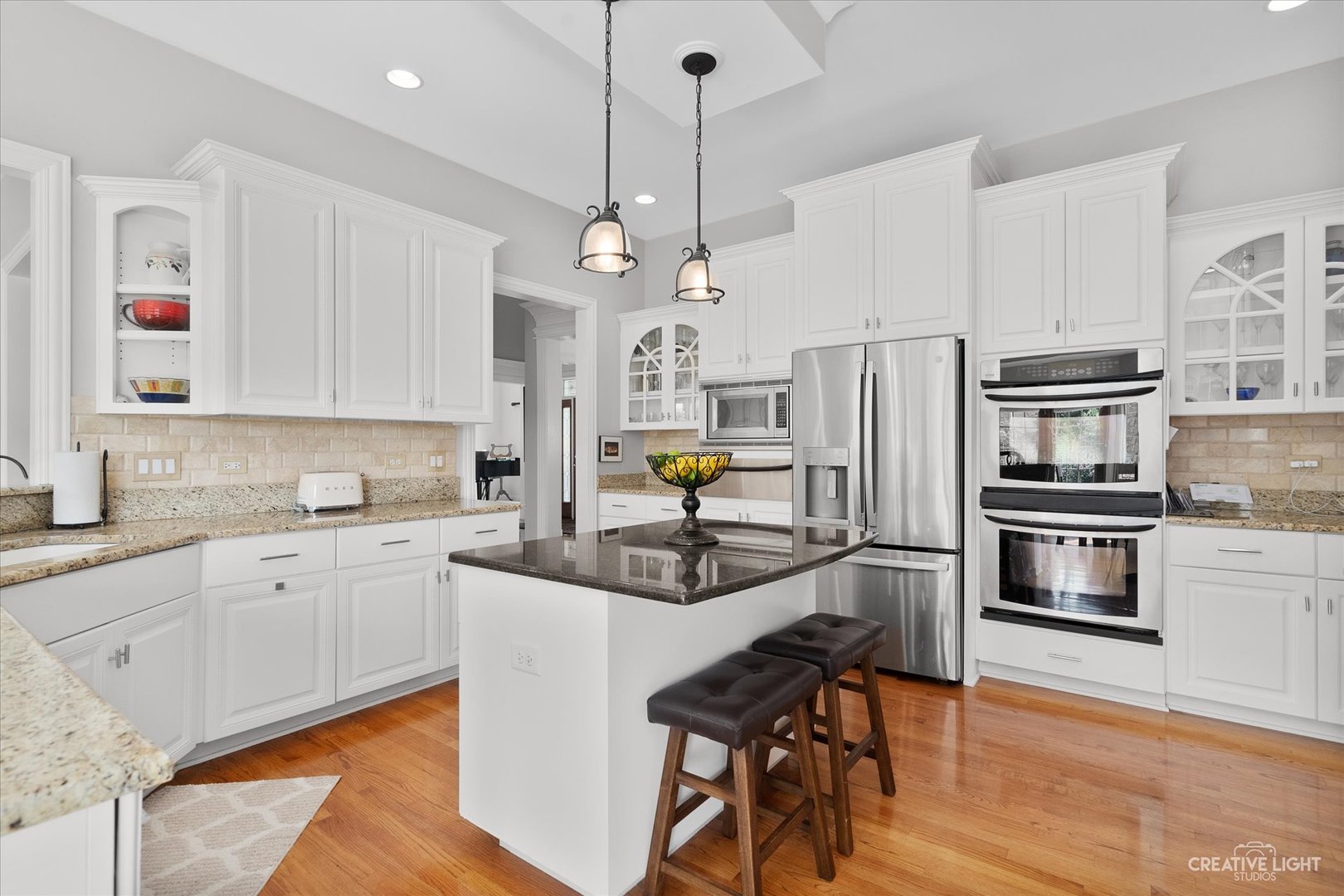 2334 Kane Lane Batavia, IL 60510 - Photo 12 of 34 a kitchen with stainless steel appliances granite countertop a stove refrigerator and white cabinets with wooden floor