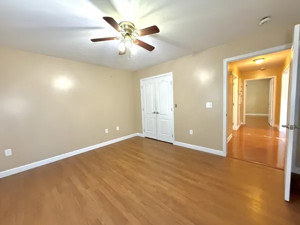 an empty room with closet and a chandelier fan