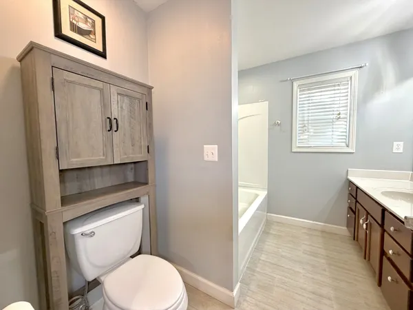 a bathroom with a toilet a sink and mirror