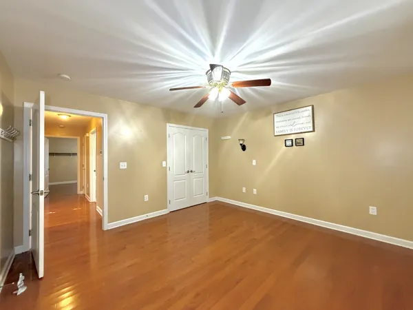 an empty room and chandelier fan in hallway