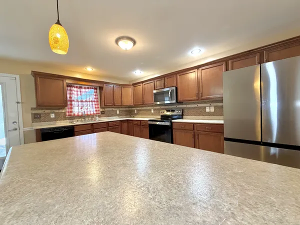a kitchen with stainless steel appliances granite countertop a refrigerator sink and cabinets