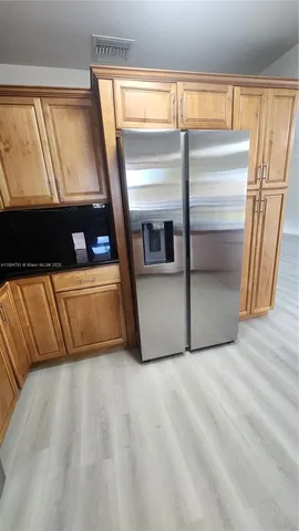 a kitchen with stainless steel appliances granite countertop a sink window and cabinets