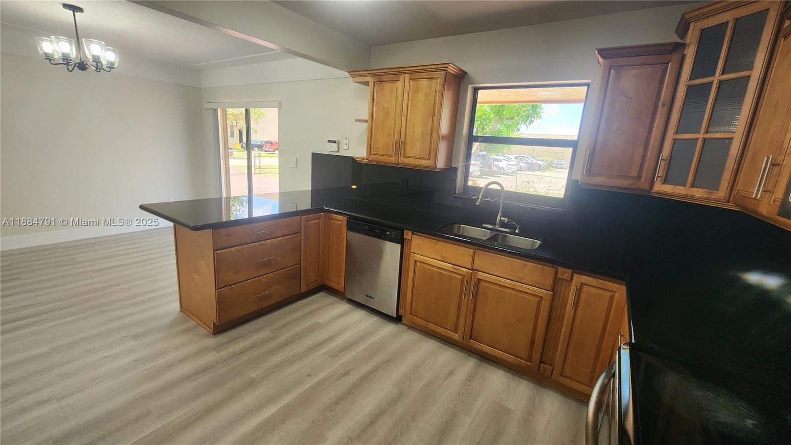 3295 Northwest 214th Street, Unit 3295 Miami Gardens, FL 33056 - Photo 12 of 19 a kitchen with stainless steel appliances granite countertop a sink window and cabinets