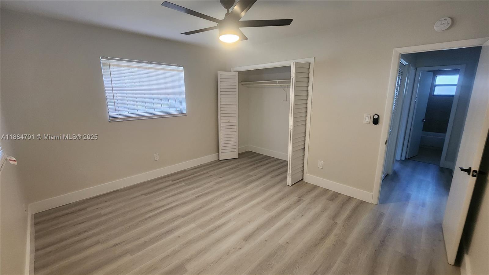 3295 Northwest 214th Street, Unit 3295 Miami Gardens, FL 33056 - Photo 15 of 19 wooden floor in an empty room with a window