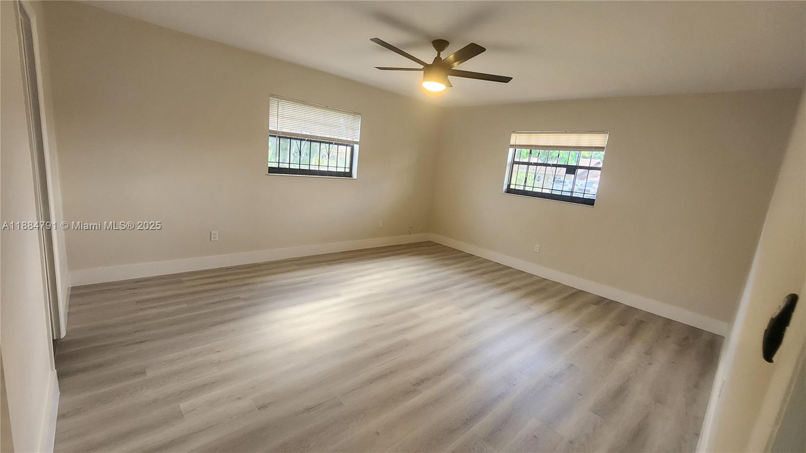 3295 Northwest 214th Street, Unit 3295 Miami Gardens, FL 33056 - Photo 16 of 19 a view of a big room with wooden floor and windows