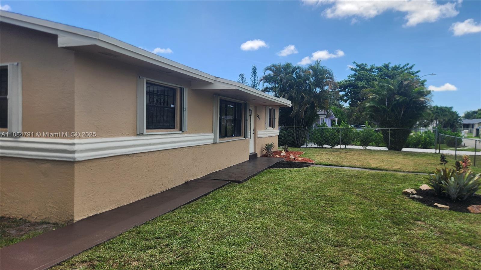 3295 Northwest 214th Street, Unit 3295 Miami Gardens, FL 33056 - Photo 3 of 19 a backyard of a house with table and chairs