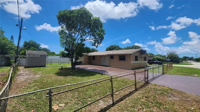 a view of a house with backyard and sitting area