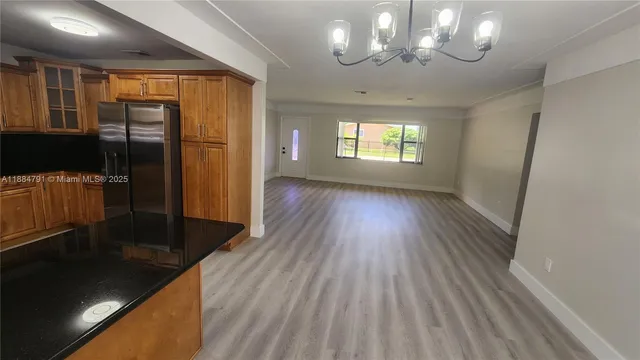 a view of a kitchen with wooden floor and a large window