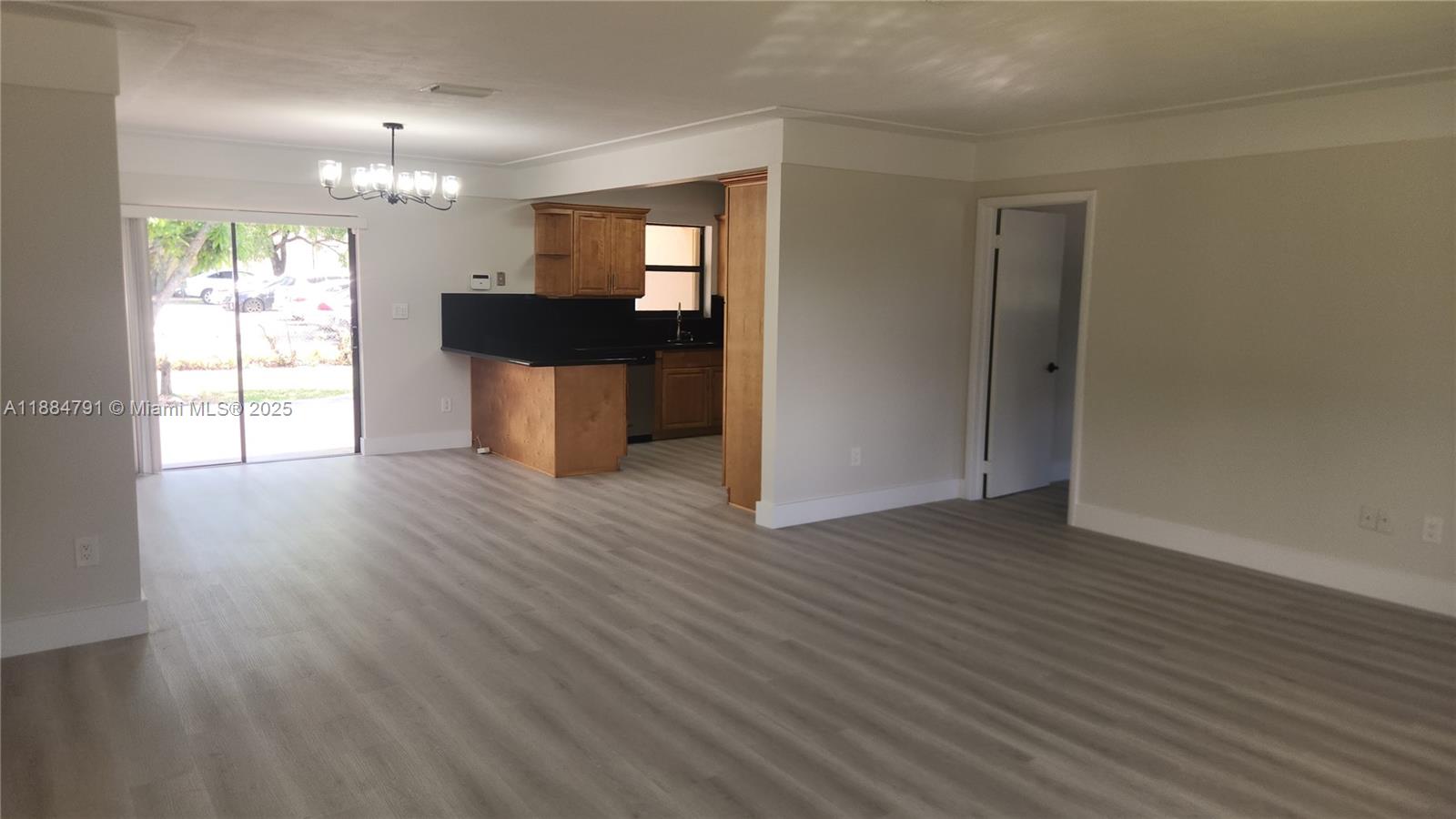3295 Northwest 214th Street, Unit 3295 Miami Gardens, FL 33056 - Photo 7 of 19 a view of a kitchen with wooden floor and a large window