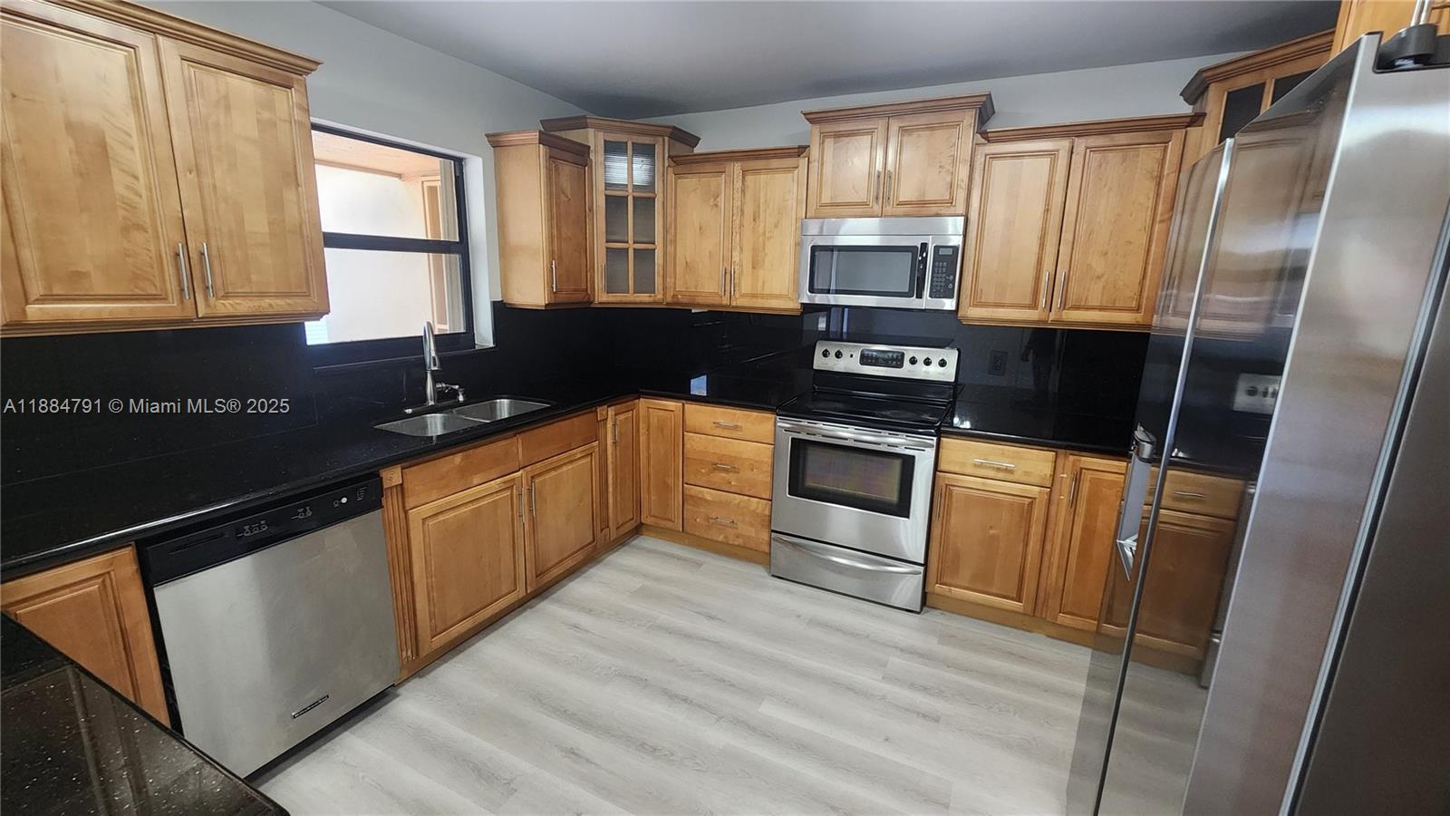3295 Northwest 214th Street, Unit 3295 Miami Gardens, FL 33056 - Photo 10 of 19 a kitchen with stainless steel appliances granite countertop a stove a sink and a refrigerator