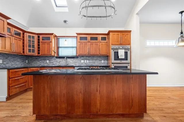 a view of a kitchen with granite countertop wooden cabinets and wooden floor