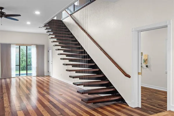 a view of a hallway with wooden floor and stairs