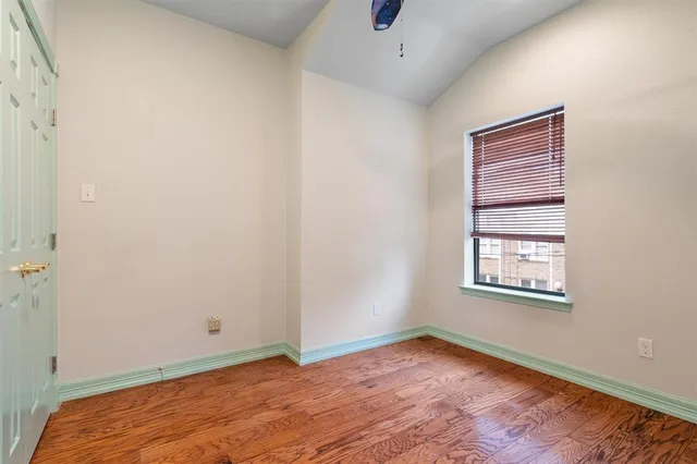 an empty room with a window and a ceiling fan