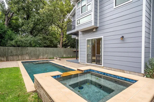 a view of a backyard with a tub and wooden fence