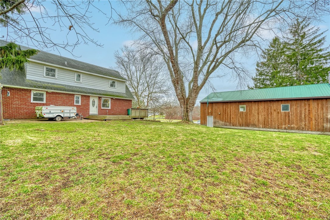 147 Basket Road Webster, NY 14580 - Photo 42 of 49 BACKYARD VIEW TO THE HOUSE AND OUTBUILDING