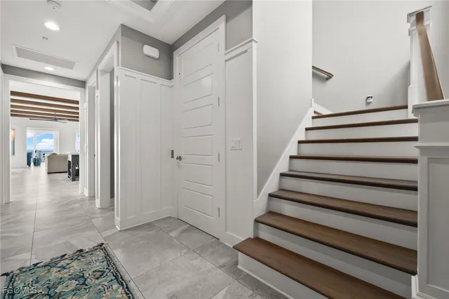 a bedroom with a bed and a large window with wooden floor
